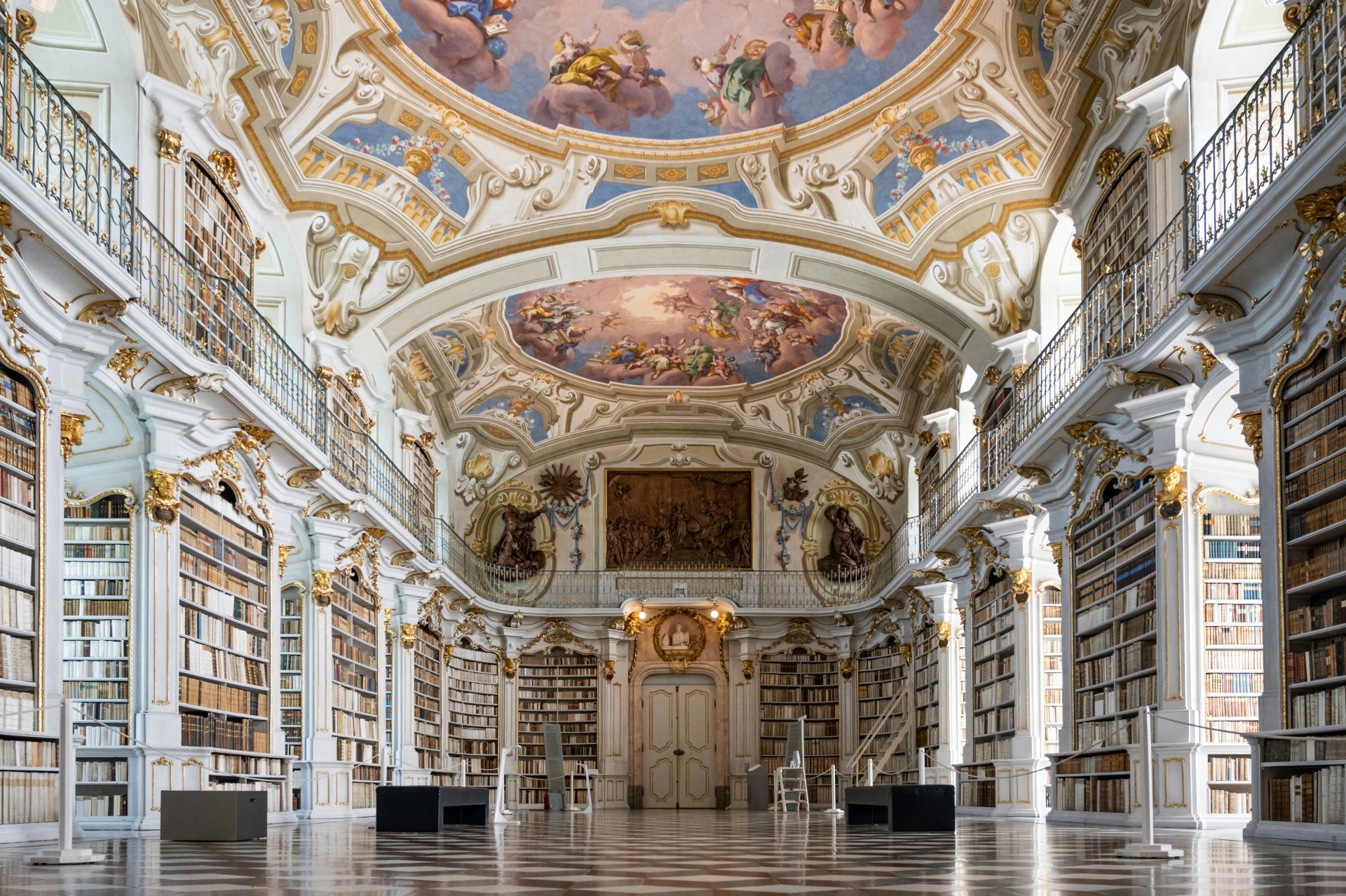 a large ornate room with a large ceiling and many bookshelves